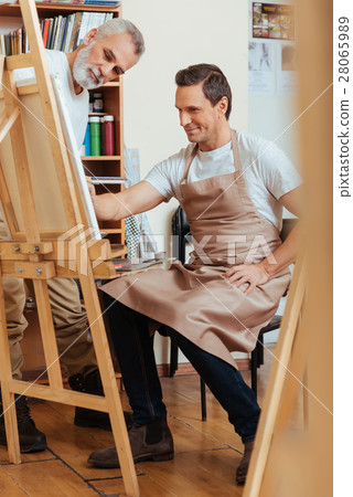 Concentrated man painting with his young colleague Concentrated man painting with his young colleague 28065989