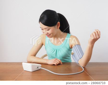 A woman measuring blood pressure A woman measuring blood pressure 28068710