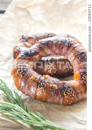 Bagels with sesame wrapped in bacon rashers 28069711