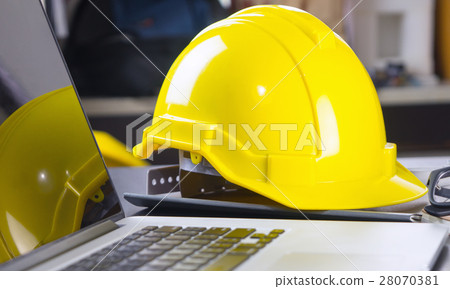Engineer hat with laptop computer on office desk. Engineer hat with laptop computer on office desk. 28070381