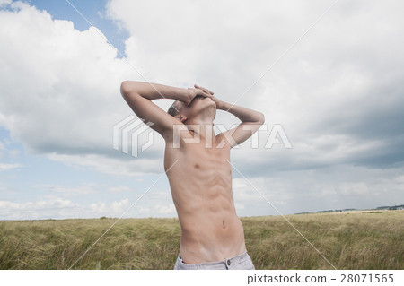 young boy stands in a field. boy in shorts. young boy stands in a field. boy in shorts. 28071565