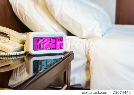 alarm clock on the bedside table 28074443