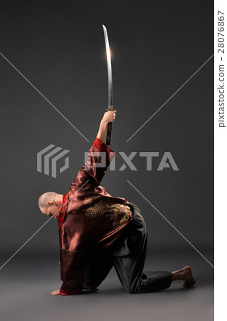 Men exercising with sword in studio 28076867