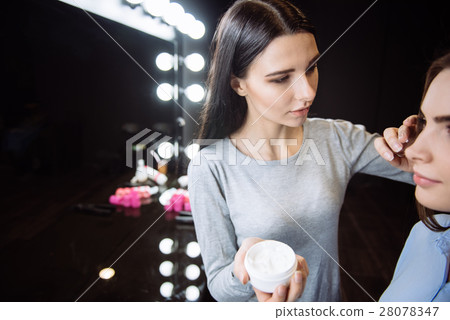 Attractive beautiful woman applying cream on her 28078347