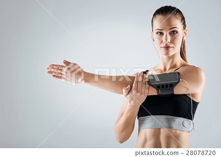 Athletic woman doing stretching on a grey Athletic woman doing stretching on a grey 28078720