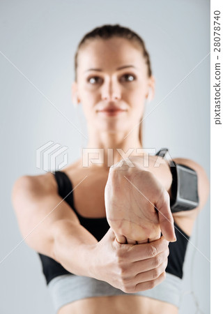 Joyful girl stretching her arm on a grey 28078740