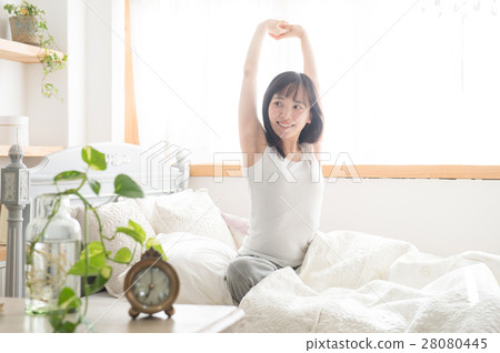 Alarm clock with young twenties who stretch to bed rising 28080445