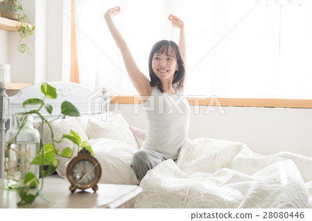 Alarm clock with young twenties who stretch to bed rising 28080446