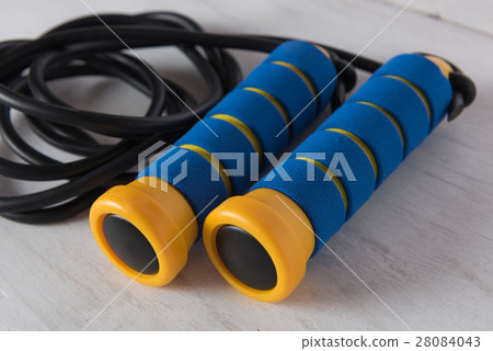 Blue and yellow skipping rope on white wooden Blue and yellow skipping rope on white wooden 28084043
