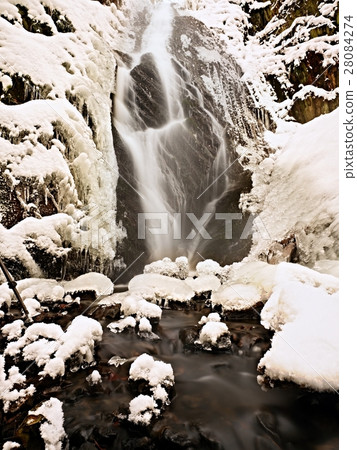 Frozen waterfall. Winter creek, icy rocky wall 28084274