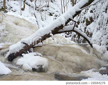 Frozen cascade of waterfall, icy boulders in foam Frozen cascade of waterfall, icy boulders in foam 28084276
