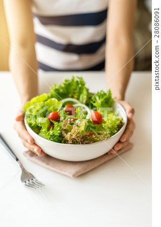 Young woman eating fresh organic vegetarian salad 28086091