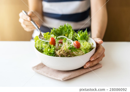 Young woman eating fresh organic vegetarian salad Young woman eating fresh organic vegetarian salad 28086092
