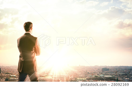 Businessman with suitcase looking at sunset 28092169