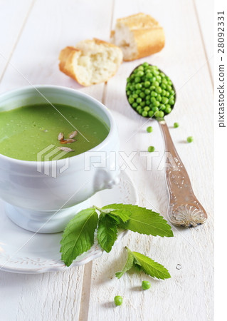 Minty Pea Soup and baguette on light background 28092331