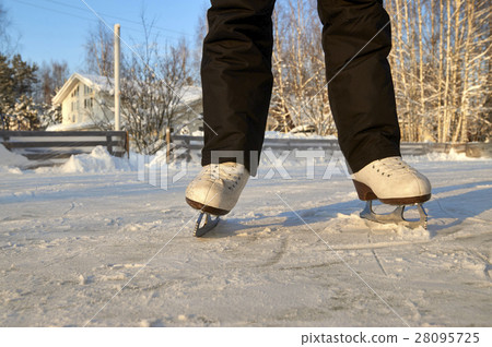 Feet of girl wearing skates on ice rink Feet of girl wearing skates on ice rink 28095725