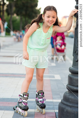 Little pretty girl on roller skates at a park 28096203
