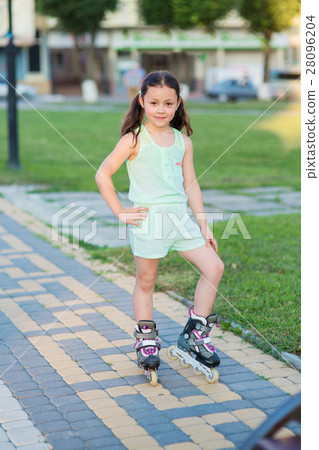 Little pretty girl on roller skates at a park 28096204