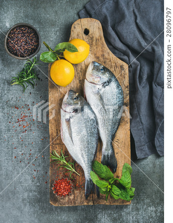 Uncooked sea bream fish with lemon, herbs, spices Uncooked sea bream fish with lemon, herbs, spices 28096797