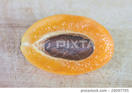 Cleaved marian plum on wooden texture background Cleaved marian plum on wooden texture background 28097705