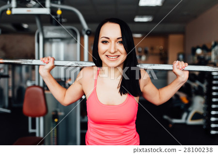 Beautiful fitness woman lifting barbell. 28100238