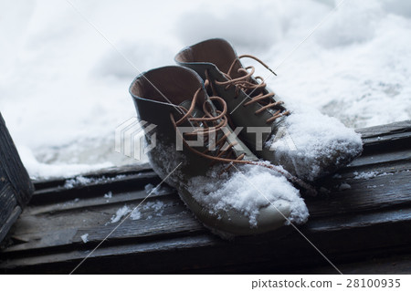 vintage leather shoes covered in snow by the door 28100935