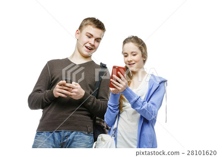 Teen boy and girl standing with mobile phones Teen boy and girl standing with mobile phones 28101620