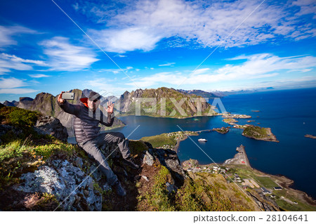 Man on top of a mountain taking a selfie 28104641