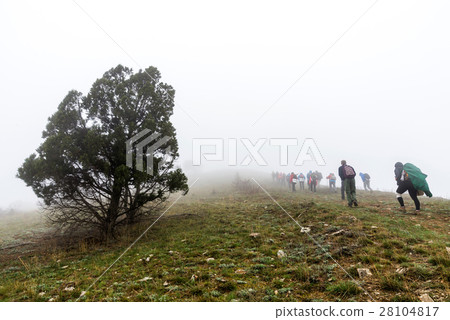 Group of tourists on the ascent through the mist 28104817