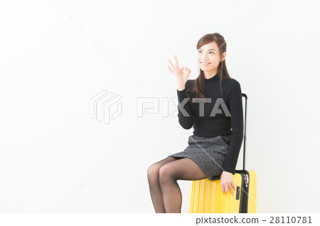 A woman sitting on a suitcase 28110781