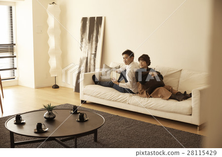 Tower apartment couple relaxing on the sofa Tower apartment couple relaxing on the sofa 28115429