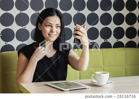 Girl looking in a vanity mirror sitting at a table Girl looking in a vanity mirror sitting at a table 28116716
