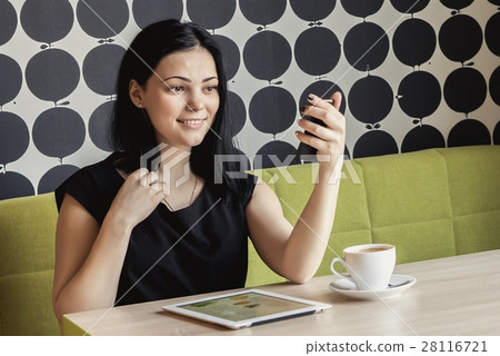 Girl looking in a vanity mirror sitting at a table Girl looking in a vanity mirror sitting at a table 28116721