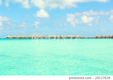 view of blue turquoise lagoon and far bungalows  28117626