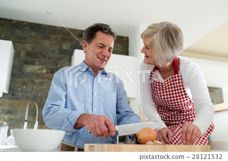 Senior couple in the kitchen cooking together. Senior couple in the kitchen cooking together. 28121532