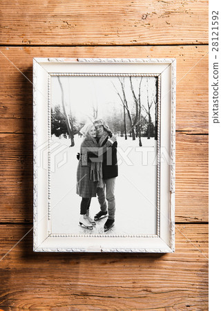 Photo of seniors in picture frame laid on wooden Photo of seniors in picture frame laid on wooden 28121592