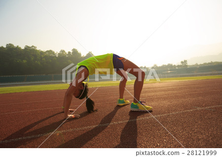young asian woman backbending on stadium track 28121999