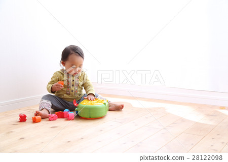 A 1 year old girl playing with a toy 28122098