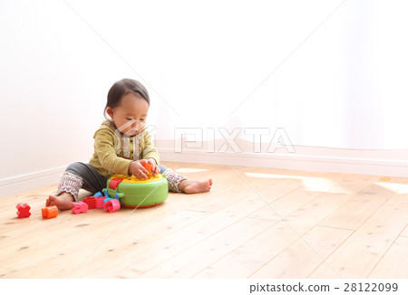 A 1 year old girl playing with a toy 28122099