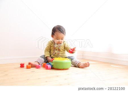 A 1 year old girl playing with a toy 28122100