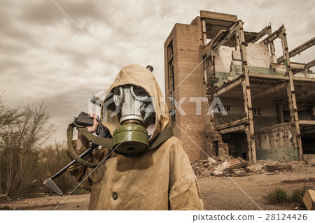 young boy stands with a gun in his hand. 28124426
