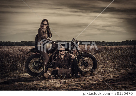Young, stylish cafe racer couple on vintage custom 28130470
