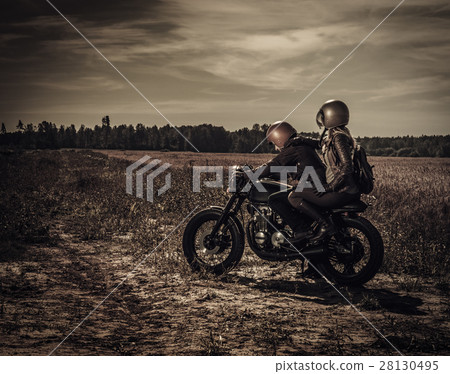 Young, stylish cafe racer couple on vintage custom 28130495