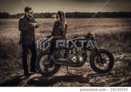 Young, stylish cafe racer couple on vintage custom Young, stylish cafe racer couple on vintage custom 28130505