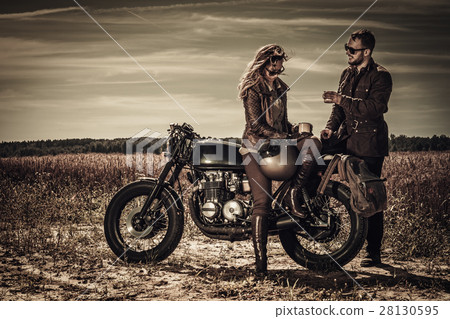 Young, stylish cafe racer couple on vintage custom Young, stylish cafe racer couple on vintage custom 28130595