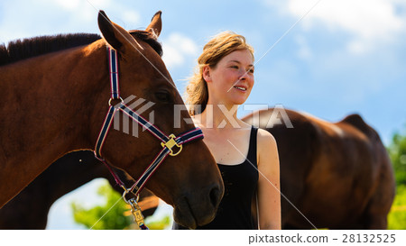 Jockey young girl petting and hugging brown horse 28132525