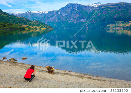 Tourist taking photo at norwegian fjord 28133300