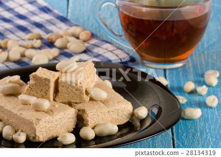 peanut halva in the plate on a blue wooden 28134319