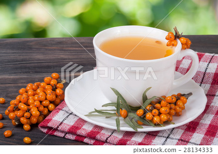 Tea of sea-buckthorn berries on wooden table with Tea of sea-buckthorn berries on wooden table with 28134333