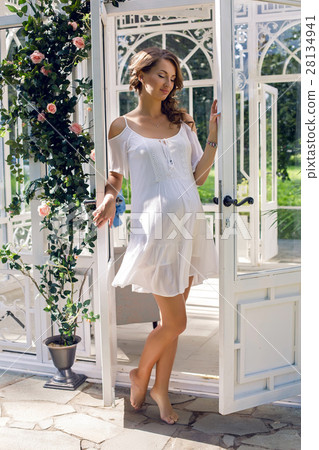 pregnant girl in a white dress on the street 28134941